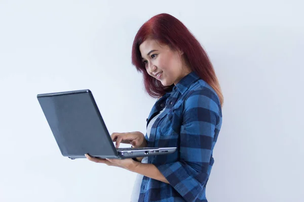 Счастливая рыжая студентка колледжа держит ноутбук — стоковое фото
