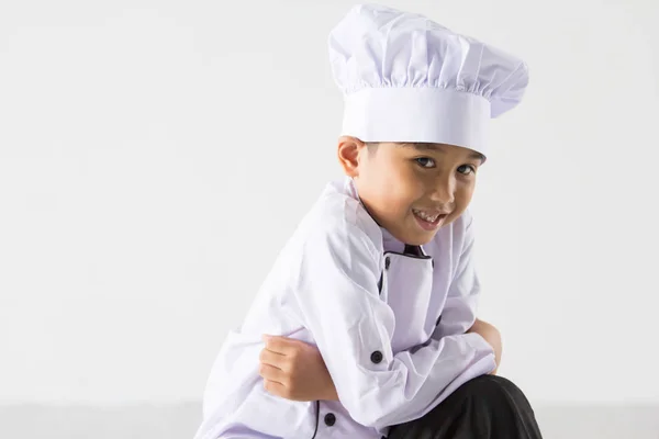 Söt pojke i kock enhetlig utgör — Stockfoto