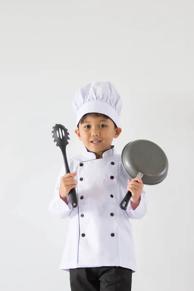 Menino bonito em uniforme de chef no fundo branco — Fotografia de Stock