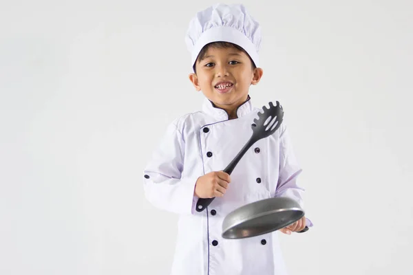 Garoto bonito em uniforme de chef no fundo branco — Fotografia de Stock