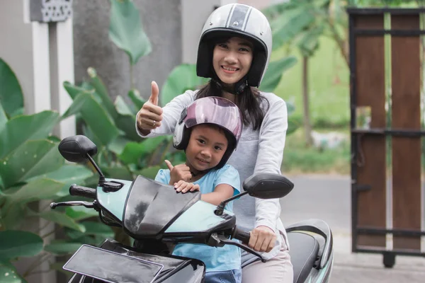 Mother and daughter riding motorbike scooter — Stock Photo, Image