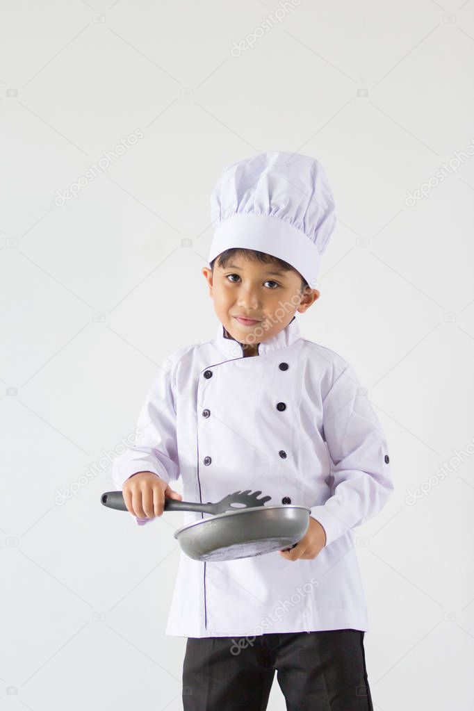 A boy in chef uniform on white background