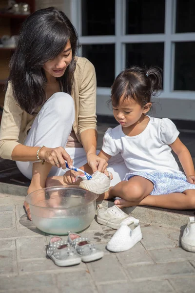Anne ve kızı birlikte Ayakkabı temizleme portresi. olumlu ebeveynlik kavramı
