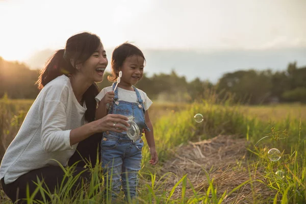 Matka a dcera se těší hrát s bublinou venkovní — Stock fotografie