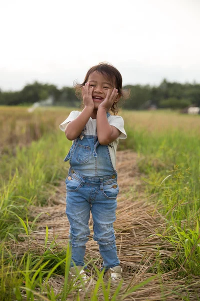 Asiático criança sorrindo para câmera em arroz paddy — Fotografia de Stock