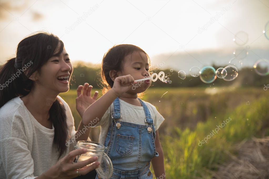 mum and kid play with bubble