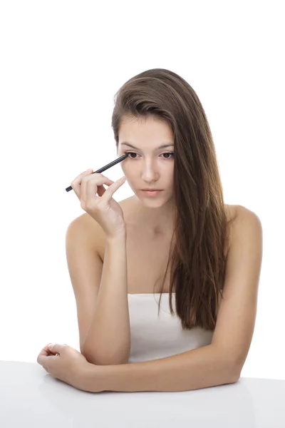 Menina bonita aplicando eyeliner — Fotografia de Stock