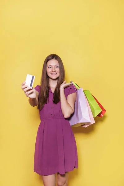 Bela menina casual com saco de compras mostrando seu carro de crédito f — Fotografia de Stock