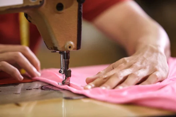 Mãos de homem costurando em uma máquina de costura em uma fábrica de roupas — Fotografia de Stock