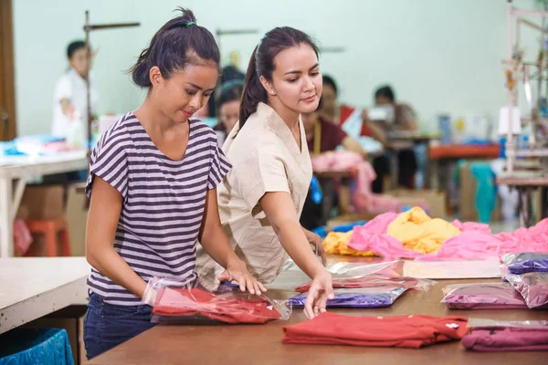 Работники текстильной фабрики упаковывают свою продукцию — стоковое фото