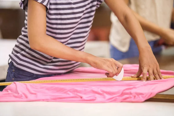 Seamstress hands marking a fabric before cutting it — Stock Photo, Image