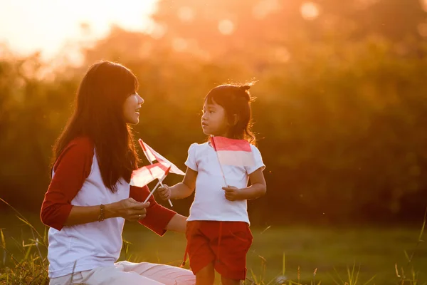 Madre e figlia alzando bandiera di indonesia — Foto Stock