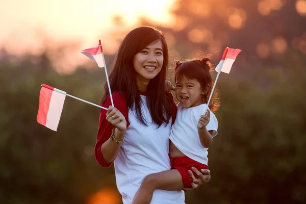 Mutter und Tochter hissen Flagge Indonesiens — Stockfoto