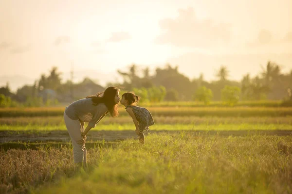 Ibu dan anak berciuman di bawah matahari terbenam langit — Stok Foto