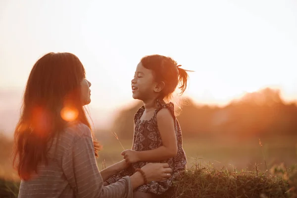 Máma a dcera v nádherné scenérii západ slunce — Stock fotografie