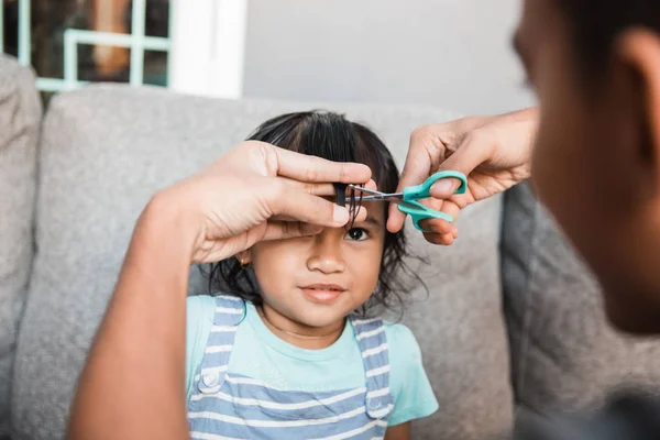 Vater schneidet kleinen Mädchen die Haare — Stockfoto