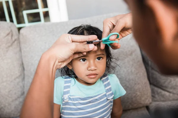 Vater schneidet kleinen Mädchen die Haare — Stockfoto