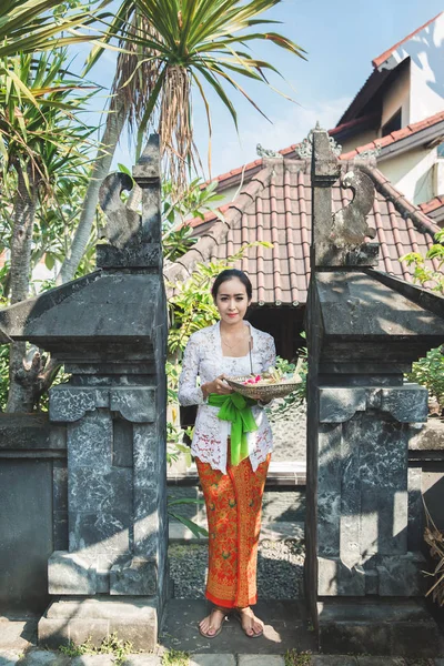 Balinesische Frau in traditioneller Kleidung bringt Canang Sari — Stockfoto