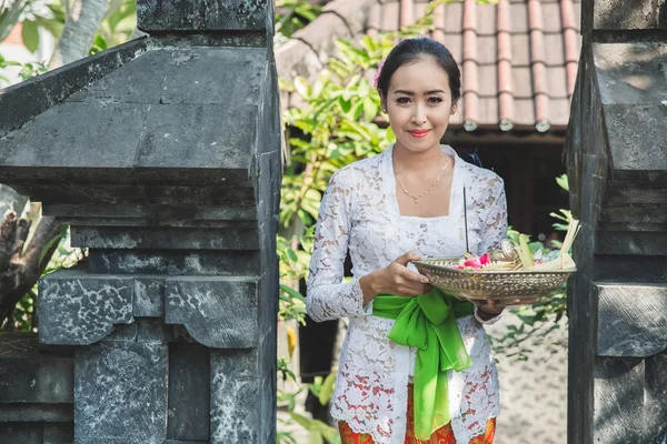 Balinese woman wearing traditional clothes bringing canang sari — Stock Photo, Image