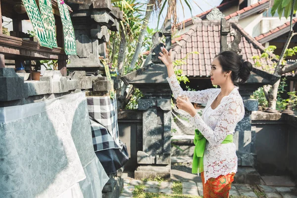 Balinesische Frau beim rituellen Darbringen von Canang Sari und beim Gebet — Stockfoto