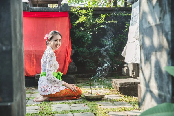 Balinesische Frau lächelt nach dem Gebet im Tempel auf kleinen Schreinen — Stockfoto