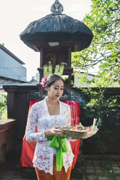 Балийская женщина молится и подношения canang сари в храме на sm — стоковое фото