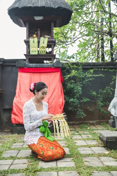 Balinese vrouw bidden en aanbod canang sari tempel op sm — Stockfoto