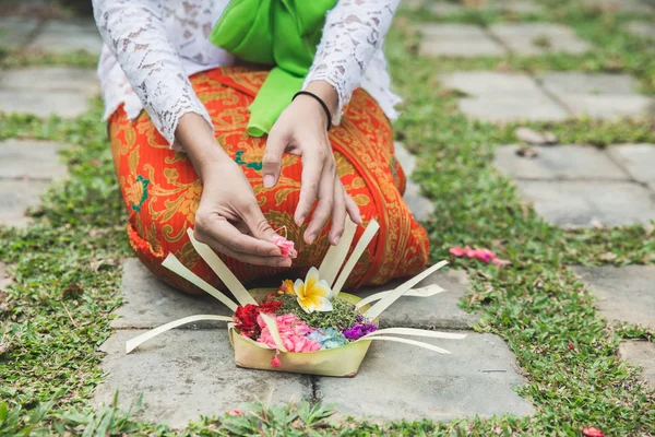 Balinese woman doing ritual offering canang sari and praying at — Stock Photo, Image