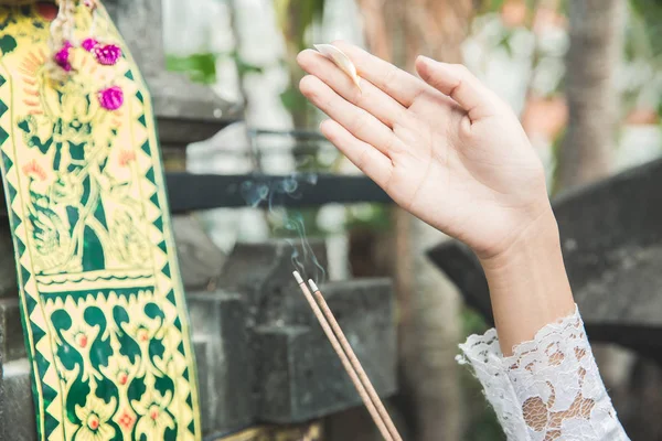 Handen van balinese vrouw doen rituele bidden met canang sari — Stockfoto