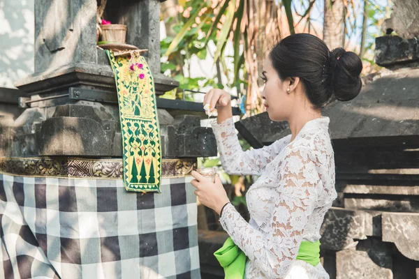 Balinesa haciendo ritual ofreciendo sari canang y orando en — Foto de Stock