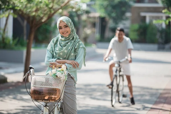 Mulher muçulmana montando uma bicicleta — Fotografia de Stock