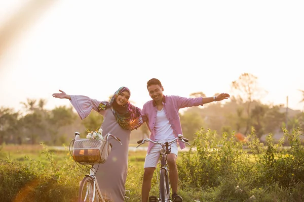 Muslim couple enjoying ride a bicycle — Stock Photo, Image