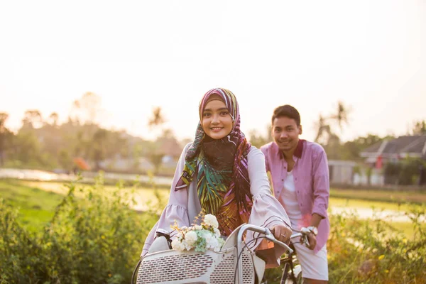 Muslim couple enjoying ride a bicycle — Stock Photo, Image