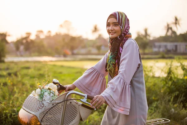 Mujer usando hijab montando una bicicleta — Foto de Stock