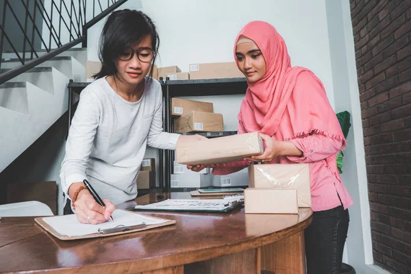 Wanita mengandalkan paket di rak — Stok Foto