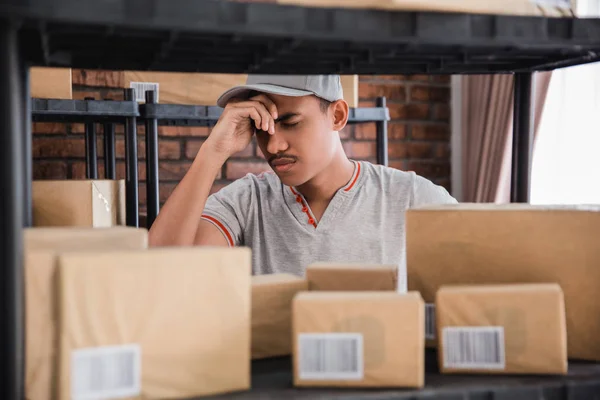 Jovem estressado verificando pacotes — Fotografia de Stock