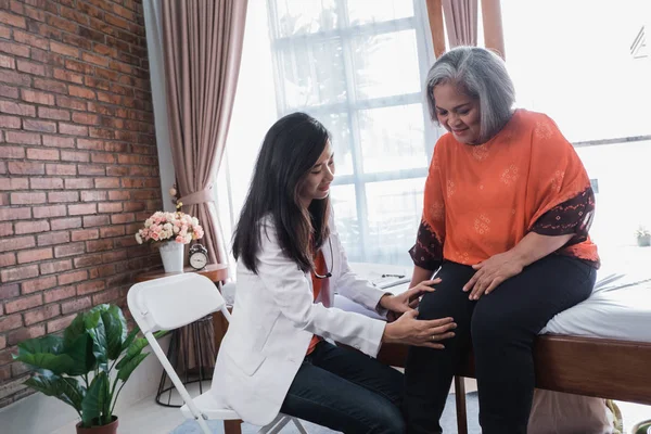 Cheking op senior vrouw gezamenlijke en knie — Stockfoto