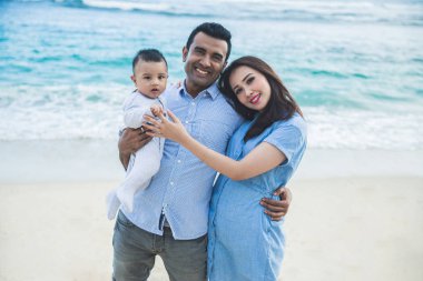 Kameraya gülümseyen güzel aile ne zaman sahilde tatil