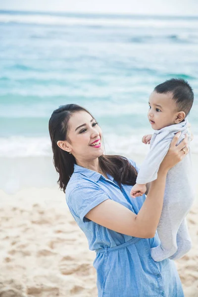 Bela mãe brincando com seus filhos na praia — Fotografia de Stock