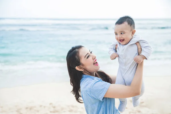 Feliz mãe brincando fora com seu filho bonito — Fotografia de Stock