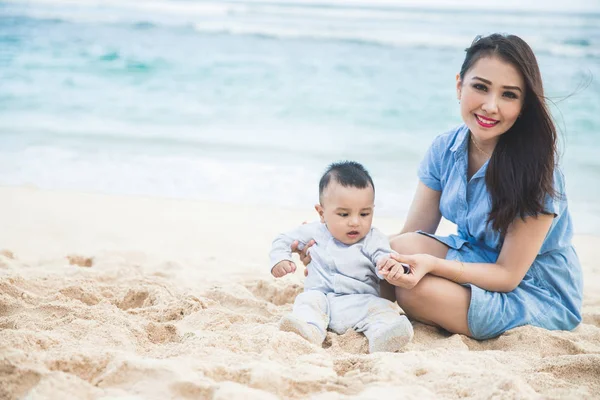 Mooie moeder met haar zoon spelen op het strand — Stockfoto