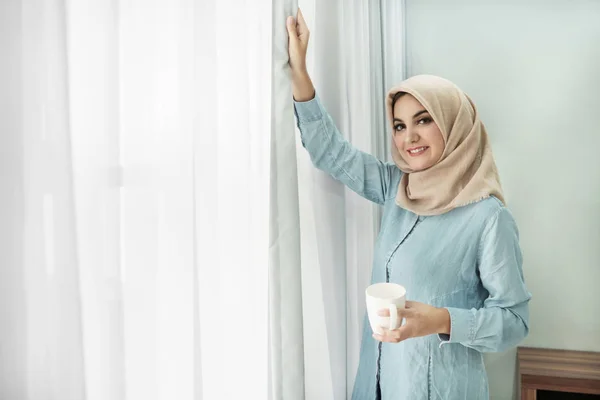 Красивая молодая женщина в хиджабе пьет чашку чая, пока — стоковое фото