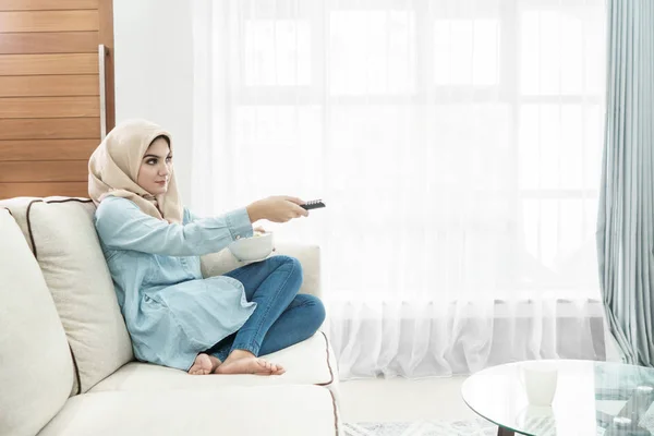 Красивая домохозяйка в хиджабе смотрит телевизор в лейзу — стоковое фото