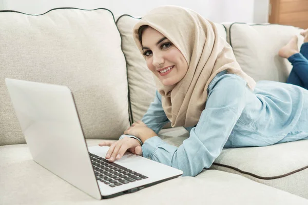 Красивая домохозяйка в хиджабе наслаждается просмотром на ноутбуке в — стоковое фото