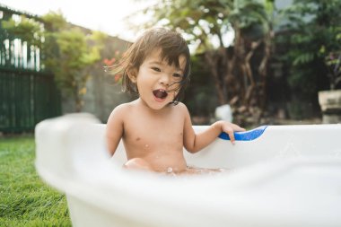 mutlu güzel kız bebek bebek küvet içinde bir banyo almak