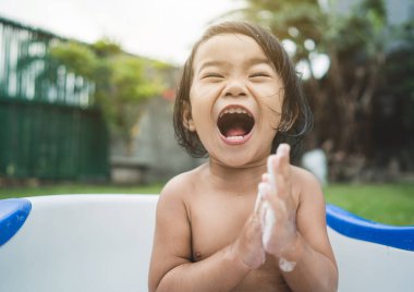 mutlu güzel kız bebek bebek küvet içinde bir banyo almak