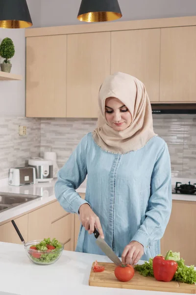 Красивая молодая женщина в хиджабе готовит овощной салат в — стоковое фото