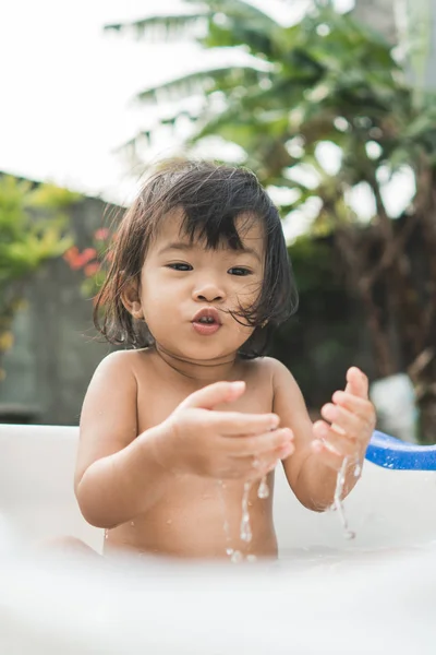 Lykkelig, vakker jente tar et bad i et babybad – stockfoto