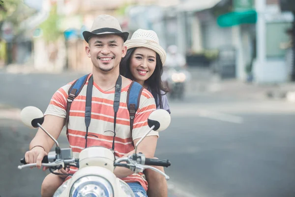 Mochileiros casal montando uma moto para iniciar sua jornada — Fotografia de Stock