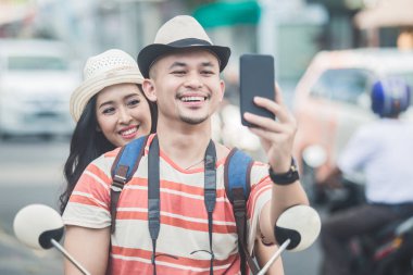 iki genç backpackers mobilephones Kamera w kullanarak selfies alarak